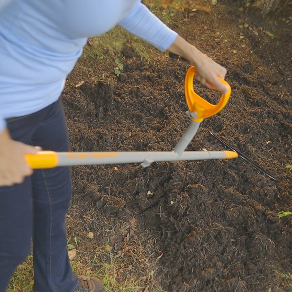 Person using the ErgieSystems 55-inch Steel Shaft Strain Reducing Bow Rake with 16 tines to rake soil.