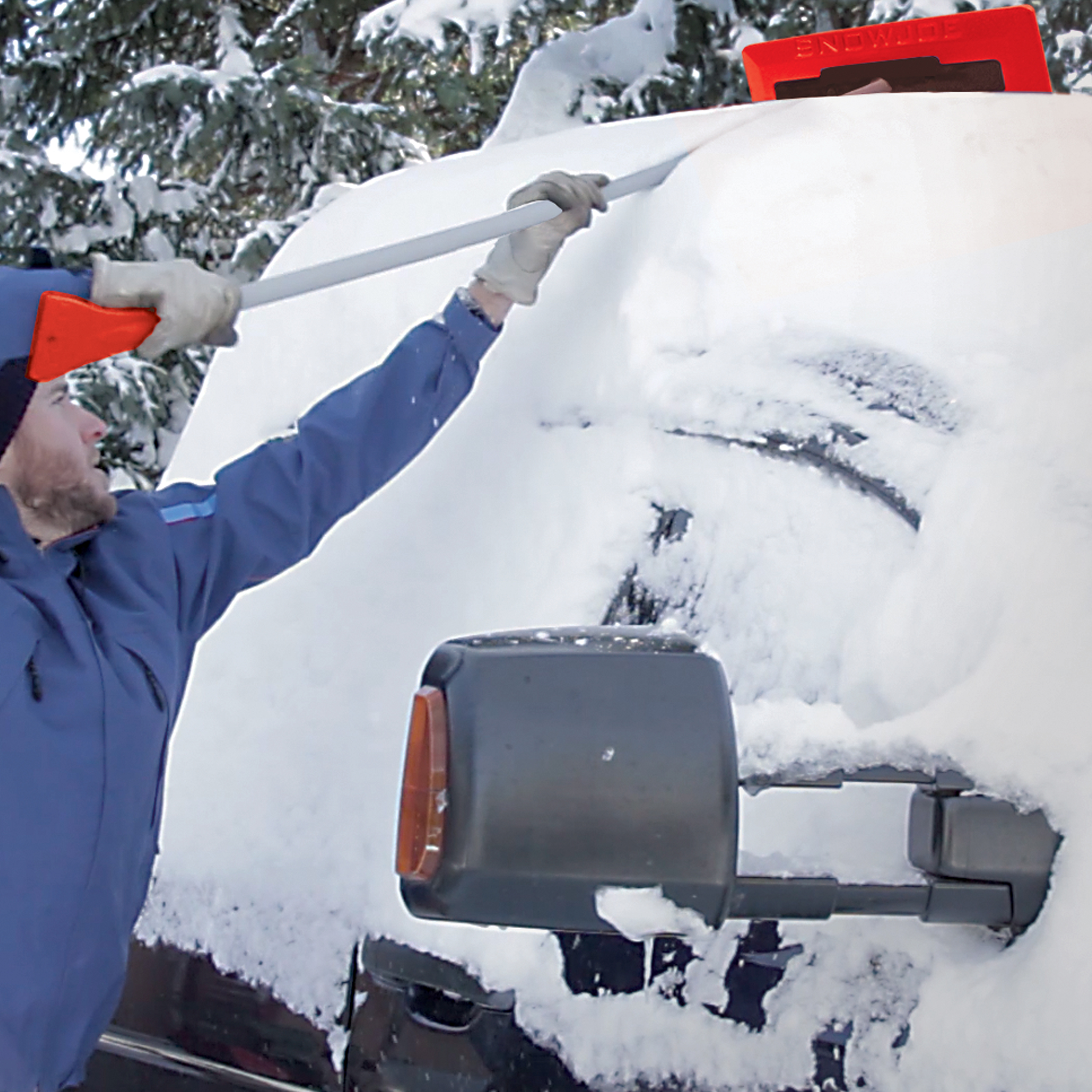 Snow Joe 18-inch 3-in-1 red-colored telescoping snow broom and ice scraper with an LED light being used to push snow off the top of a car.